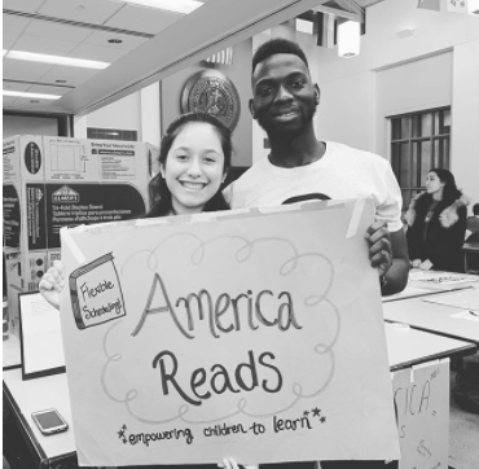 photo of two volunteers holding the American Reads sign board